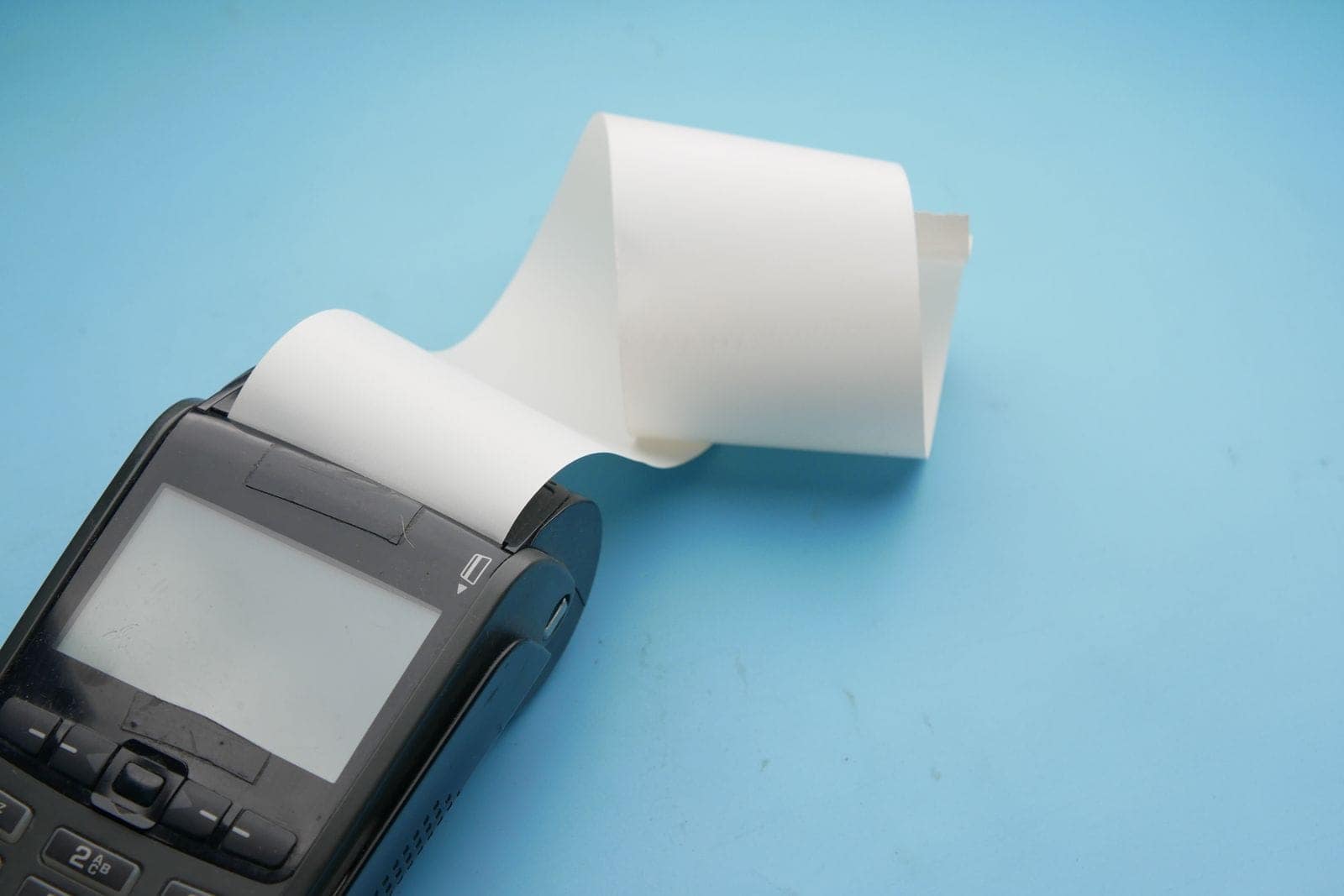 Terminal de pagamento com um rolo de papel térmico a sair da ranhura